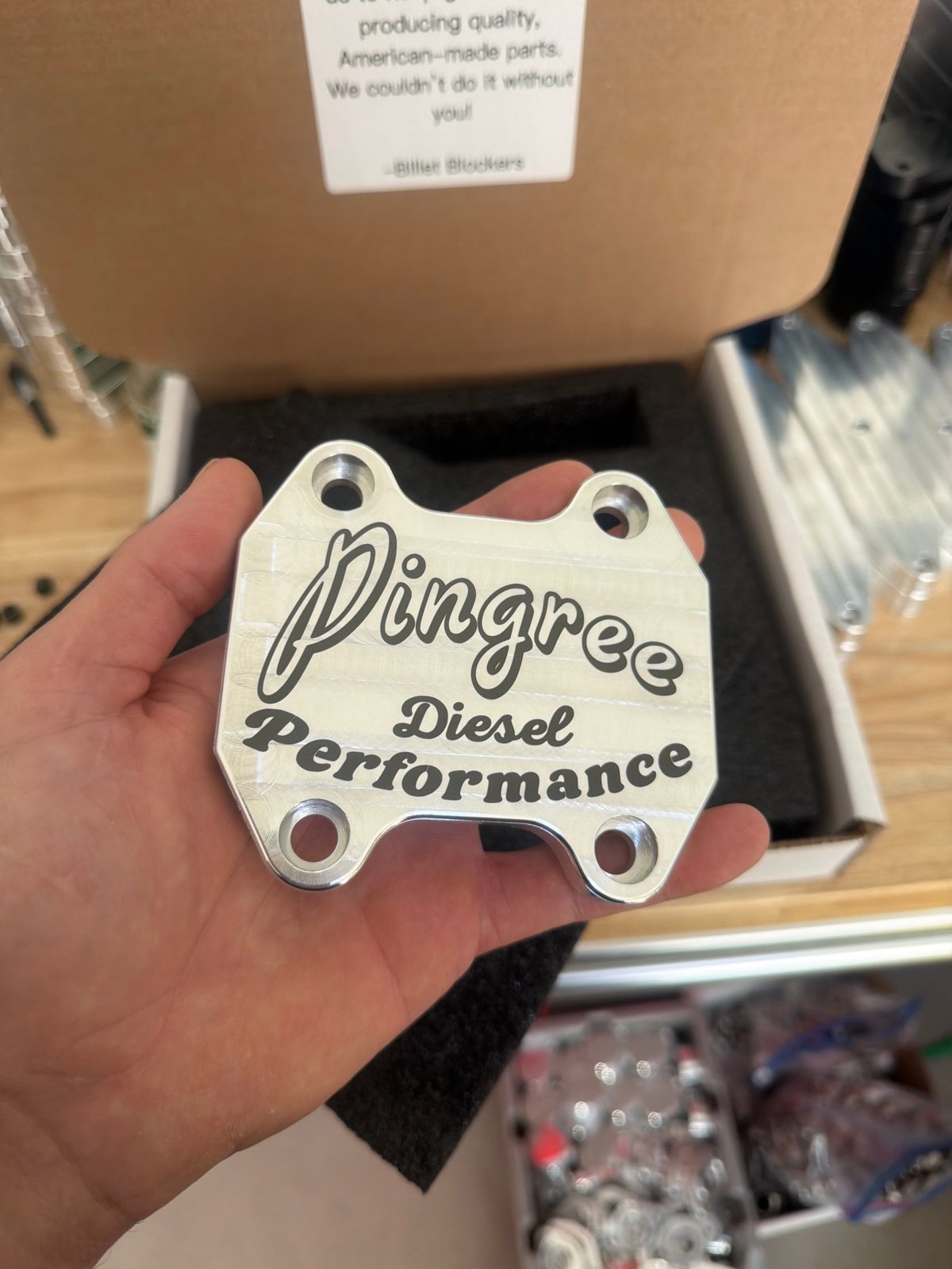 A handheld metal component bearing Pingree Diesel Performance lettering.